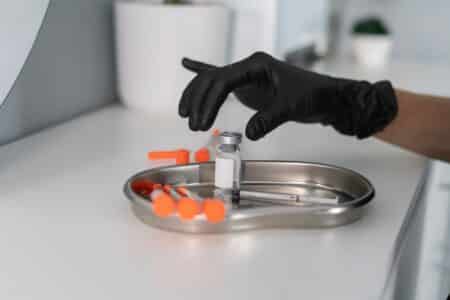 A,cosmetologist,organizes,multiple,syringes,and,a,vial,in,a