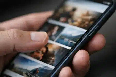 Main tenant un smartphone affichant un magazine numérique. Découvrez pourquoi s'abonner à Social Mag transforme l'accès.