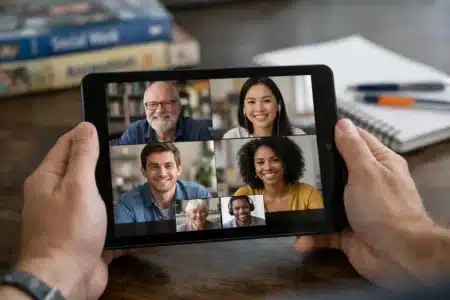 Mains tenant une tablette avec visioconférence pour l'animation et l'action sociale