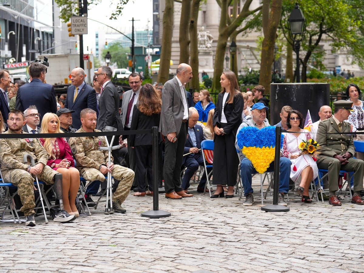 Foule de personnes rassemblées pour un événement commémoratif en plein air.