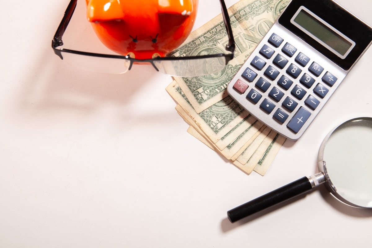 Calculatrice, lunettes, argent, loupe, objet rouge en verre.