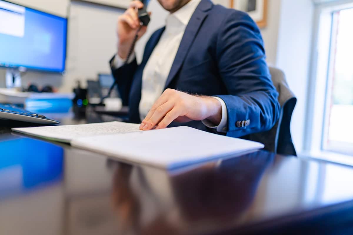 Un homme assis à un bureau écrivant sur un papier.