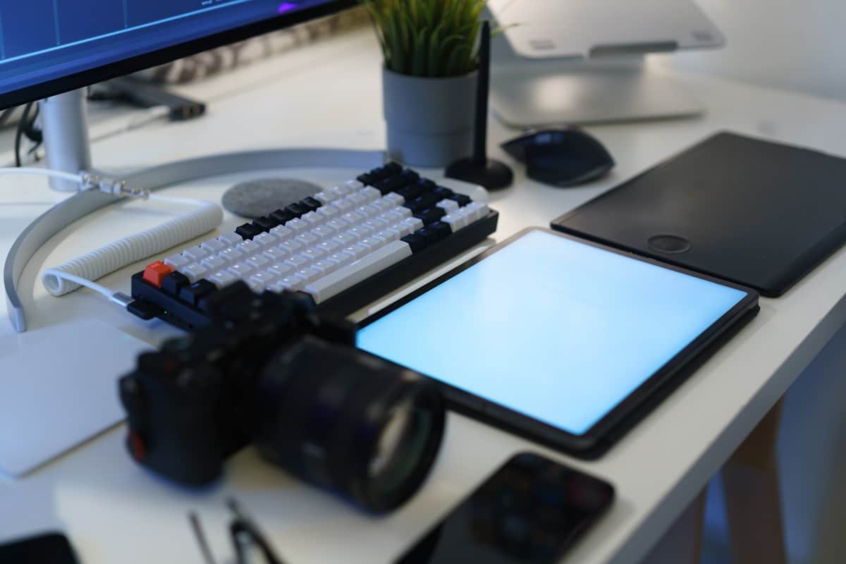 Bureau de travail avec clavier, souris, tablette et écran d'ordinateur.