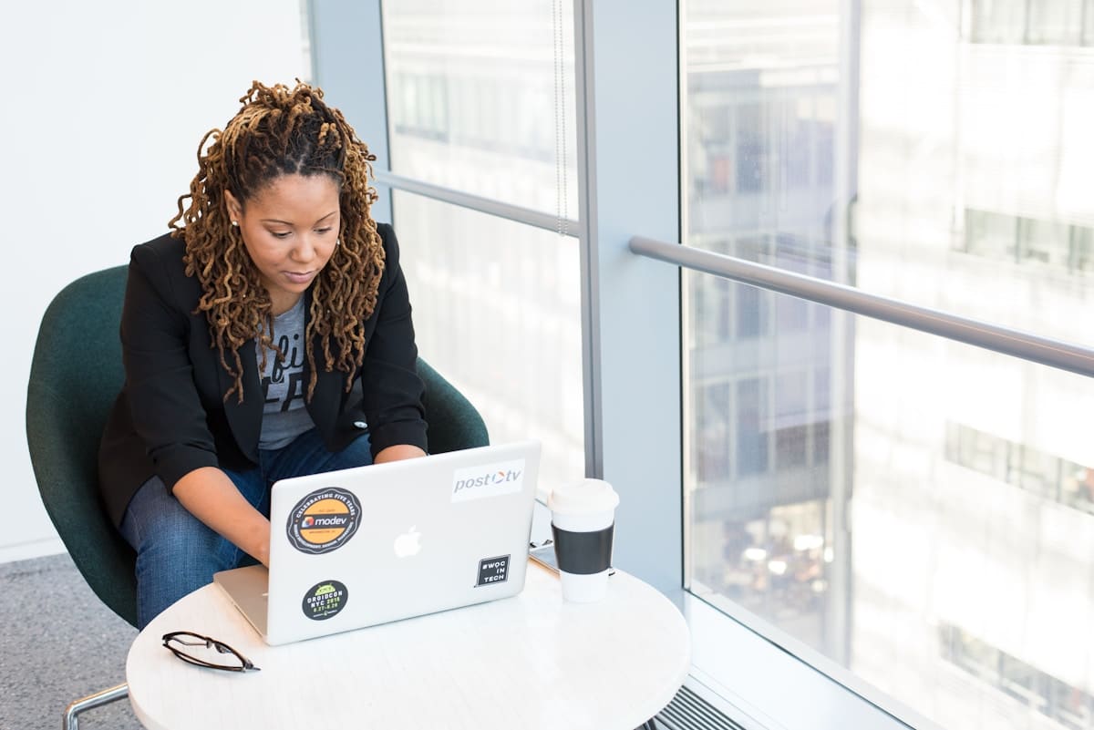 Femme afro-américaine travaillant sur un ordinateur portable dans un bureau.