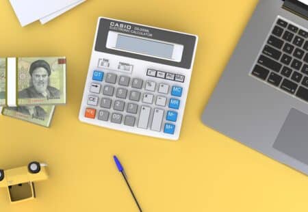 "Un calculateur sur un bureau à côté d'un ordinateur portable pour faciliter le calcul de votre retraite complémentaire, outi