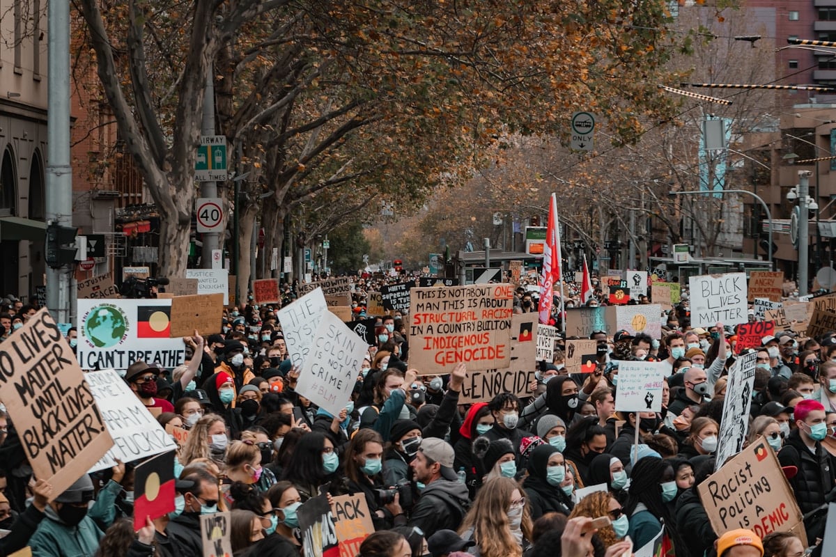 Foule de manifestants brandissant des pancartes lors d'une manifestation.