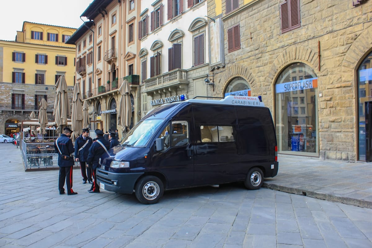 Véhicule de police italien stationné dans une place historique de Florence.