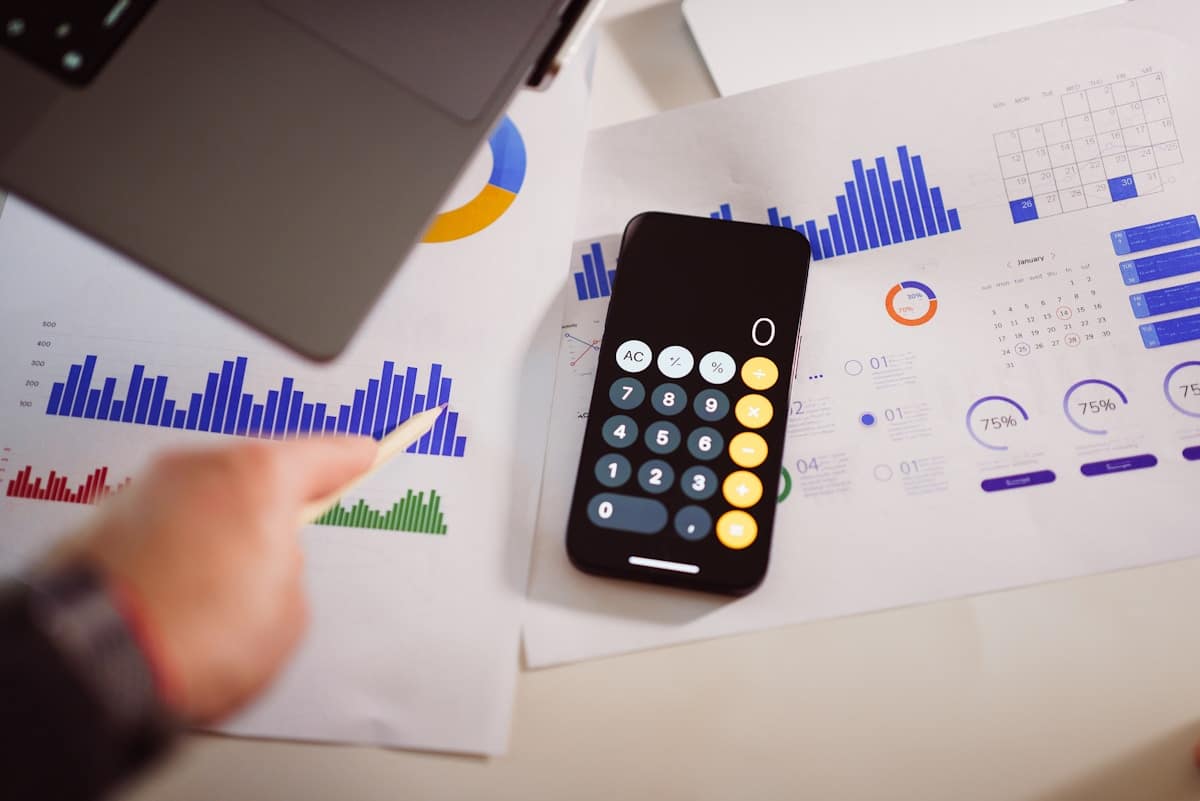 Graphiques, calculatrice, documents financiers, analyse de données, bureau.