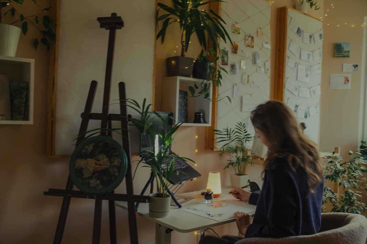 Artiste peignant dans un studio cosy et verdoyant.