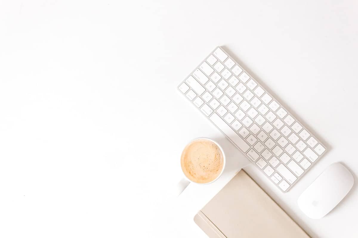 Bureau de travail minimaliste avec clavier et tasse de café.