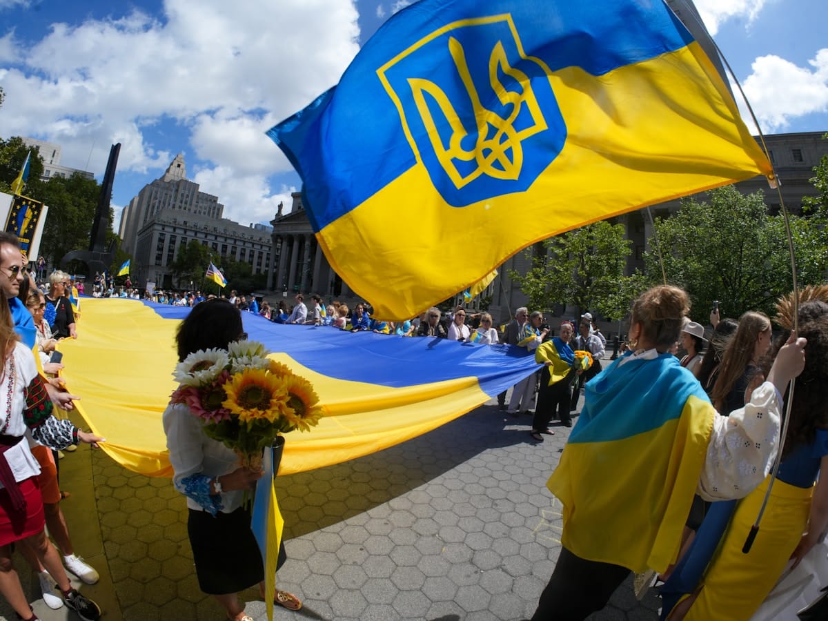 Défilé patriotique ukrainien avec drapeaux, fleurs et foule.