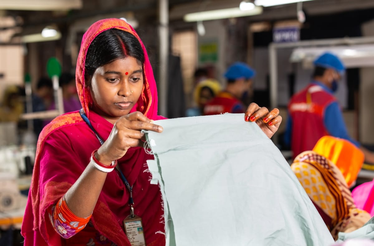 Femme en vêtements rouges travaillant dans un atelier textile.
