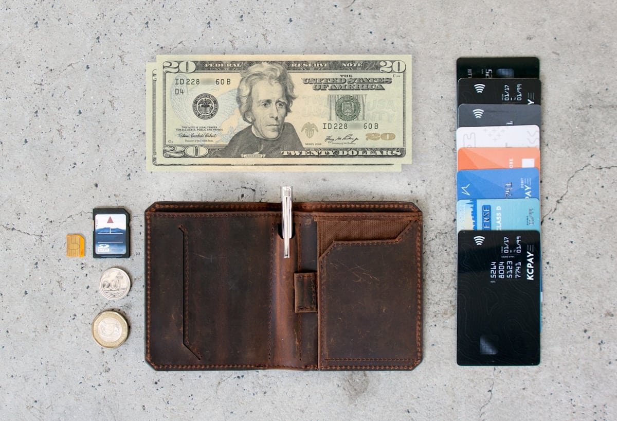 Portefeuille en cuir, billet de 20 dollars, cartes de crédit et pièces de monnaie.