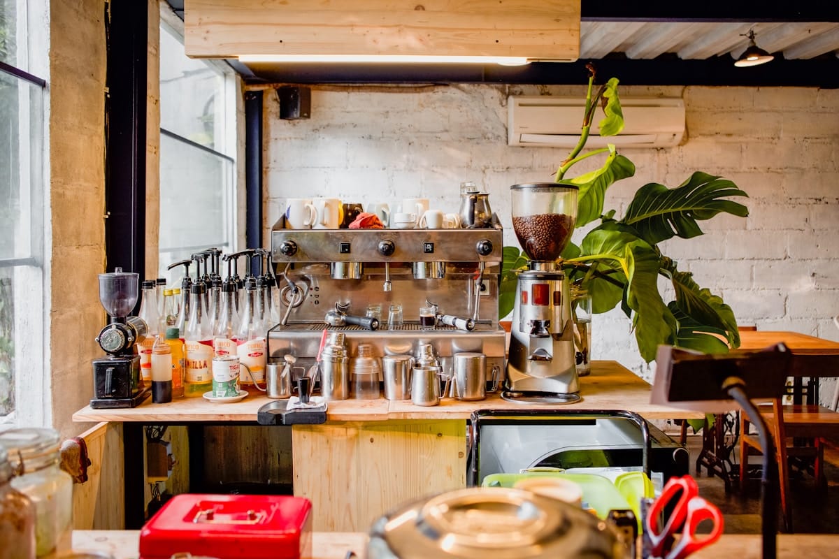 Équipement de cuisine professionnel avec machine à café et accessoires.
