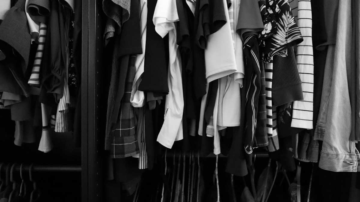 Vêtements suspendus dans un placard en noir et blanc.