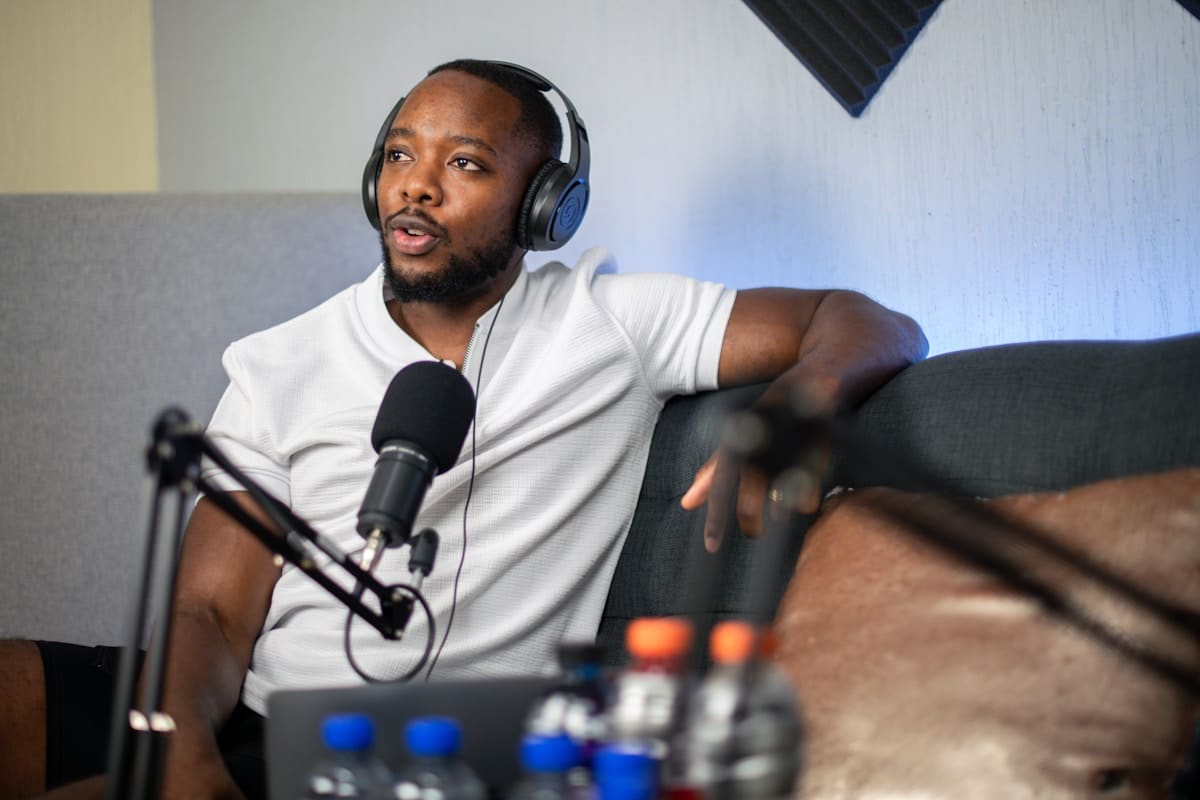 Homme afro-américain avec un casque d'écoute enregistrant un podcast.