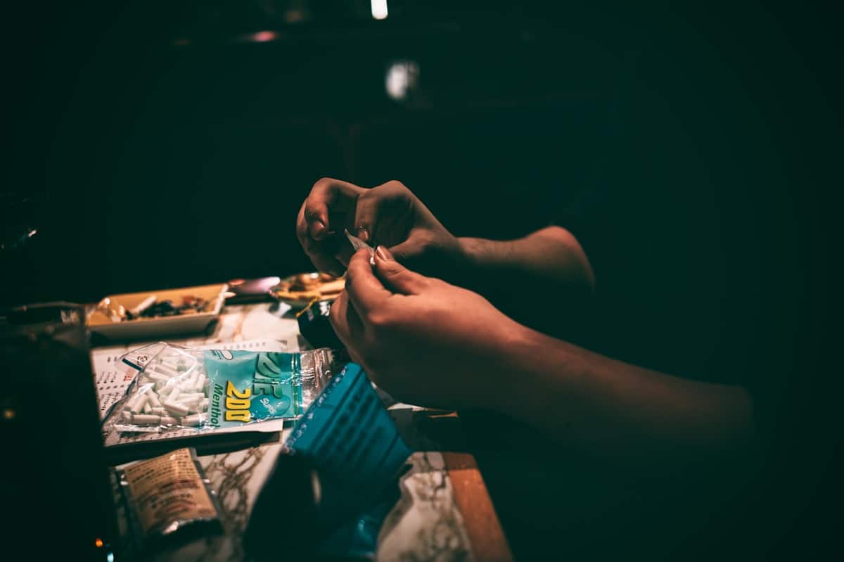 Mains préparant une substance illégale dans un environnement sombre.