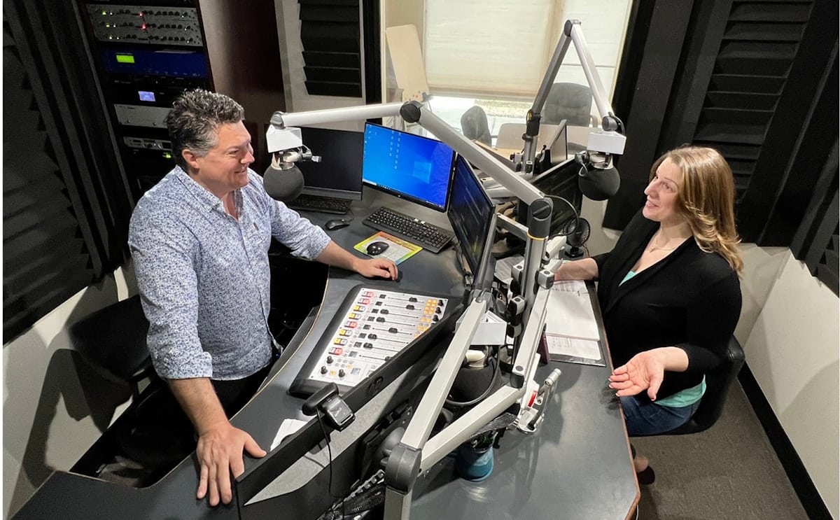 Deux personnes travaillant sur un équipement audiovisuel complexe dans un studio.