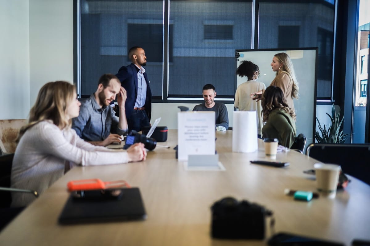 Groupe de personnes en réunion dans un bureau moderne.