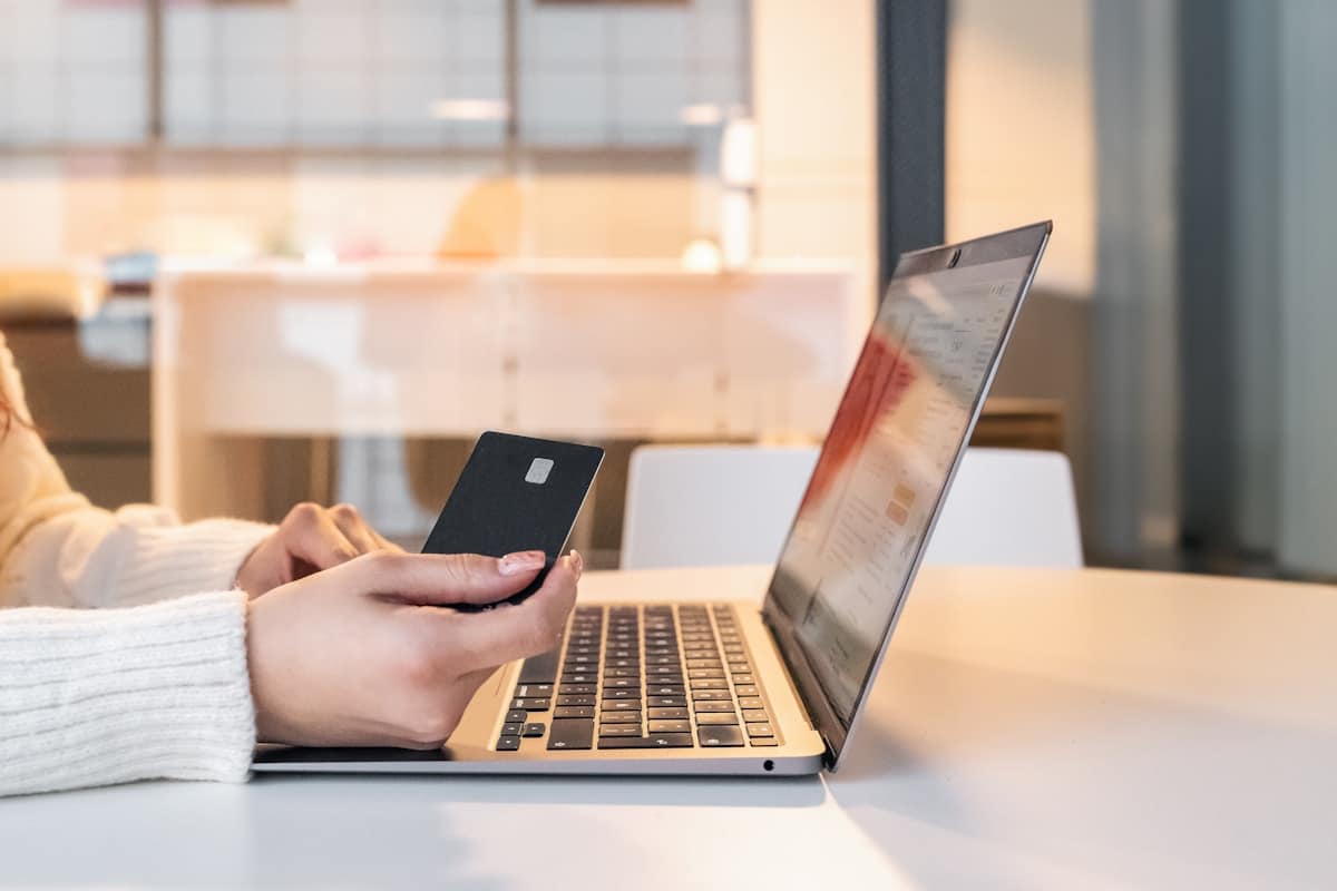 Personne utilisant un ordinateur portable et un téléphone portable dans un bureau.