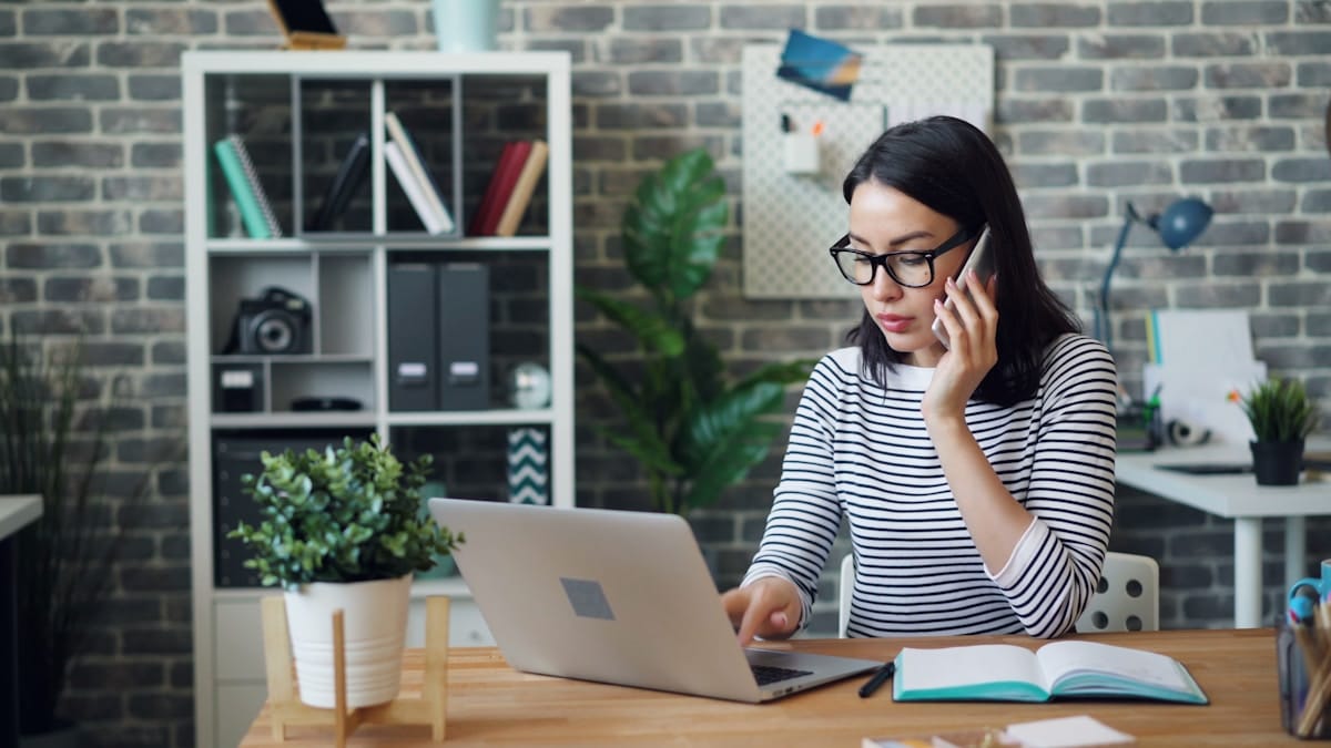 Femme travaillant sur ordinateur portable dans un bureau moderne.